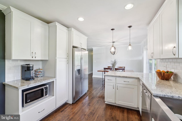 kitchen with white cabinetry, a peninsula, stainless steel appliances, and tasteful backsplash