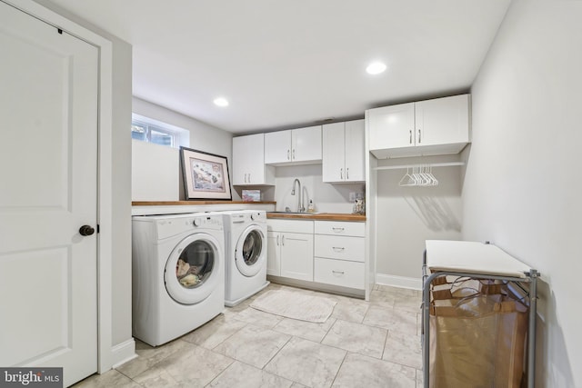 washroom featuring a sink, cabinet space, washing machine and clothes dryer, marble finish floor, and recessed lighting