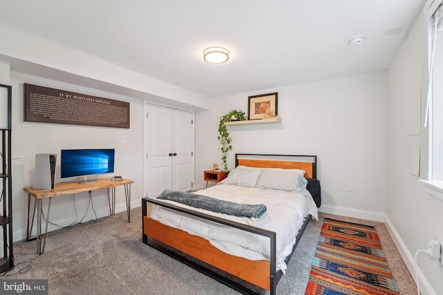 carpeted bedroom with baseboards and a closet
