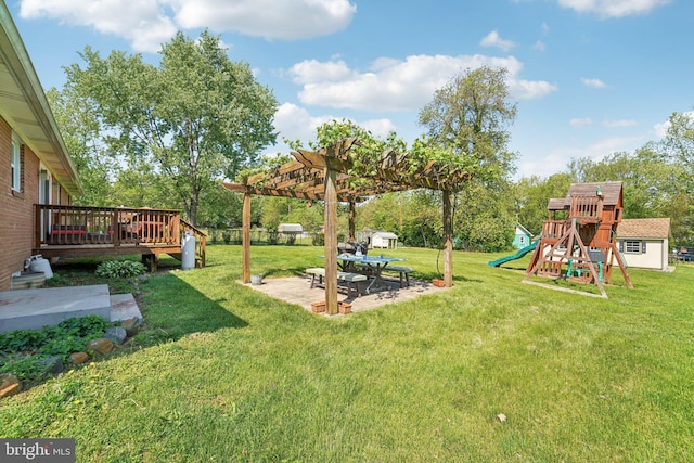 view of yard featuring a playground, a patio, a pergola, and a wooden deck