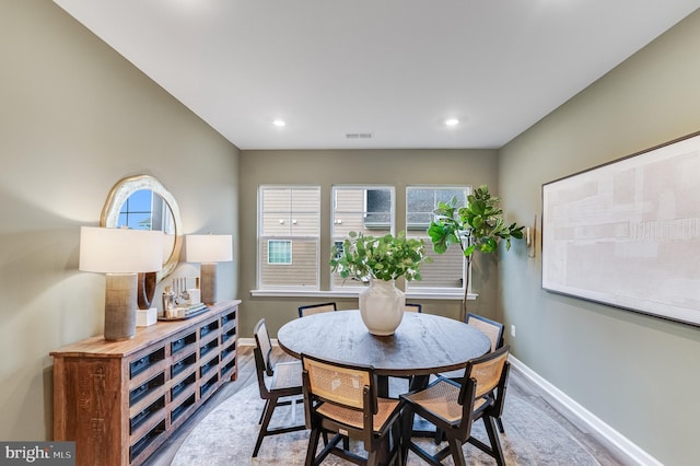 dining space featuring baseboards, recessed lighting, wood finished floors, and a wealth of natural light
