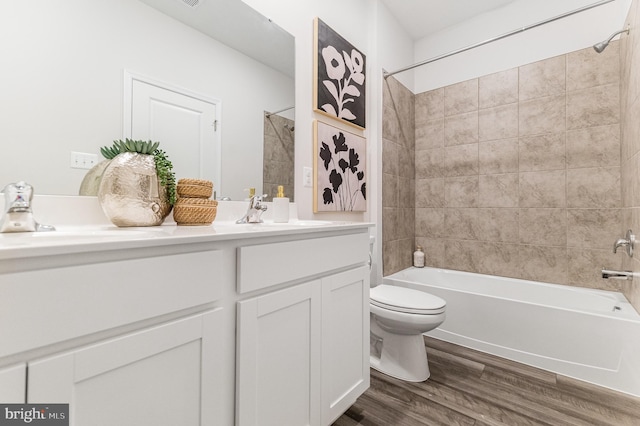 bathroom featuring vanity, toilet, wood finished floors, and tub / shower combination