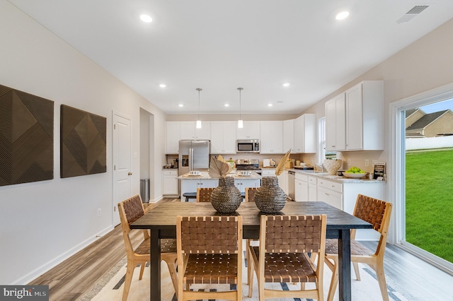 dining area with plenty of natural light, recessed lighting, light wood-style flooring, and visible vents