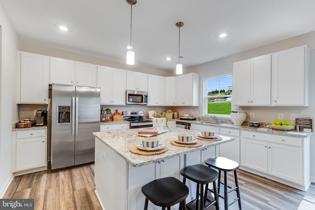 kitchen featuring a sink, light wood-style flooring, white cabinetry, and stainless steel appliances