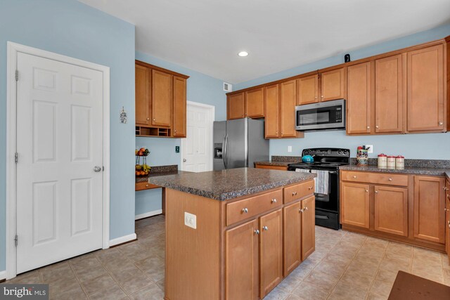 kitchen with dark countertops, a center island, stainless steel appliances, and recessed lighting