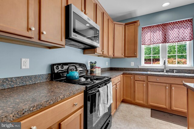 kitchen featuring dark countertops, a sink, black electric range, recessed lighting, and stainless steel microwave