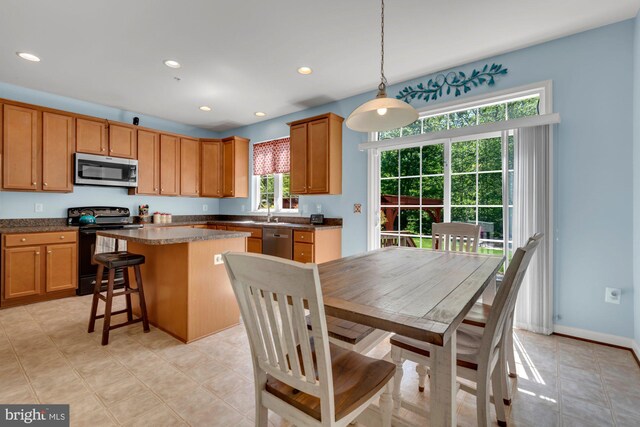 kitchen with dark countertops, a center island, stainless steel appliances, and recessed lighting