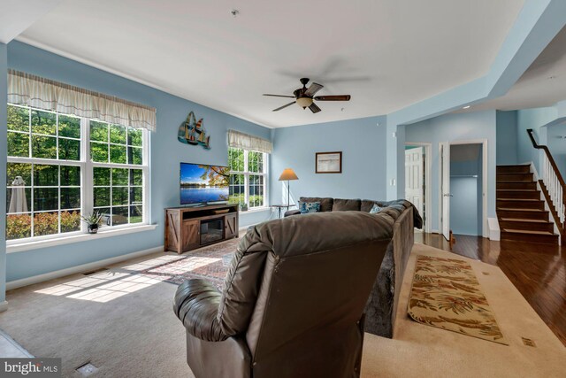 living area with ceiling fan, stairs, baseboards, wood finished floors, and visible vents