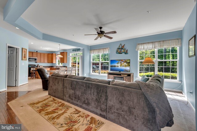 living room with baseboards, a ceiling fan, light wood-style flooring, and recessed lighting