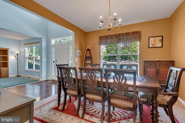 dining area featuring an inviting chandelier, baseboards, wood finished floors, and a healthy amount of sunlight