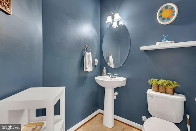 bathroom with baseboards, tile patterned flooring, and toilet