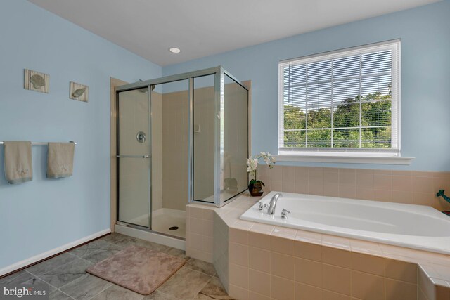 bathroom featuring a shower stall and a bath