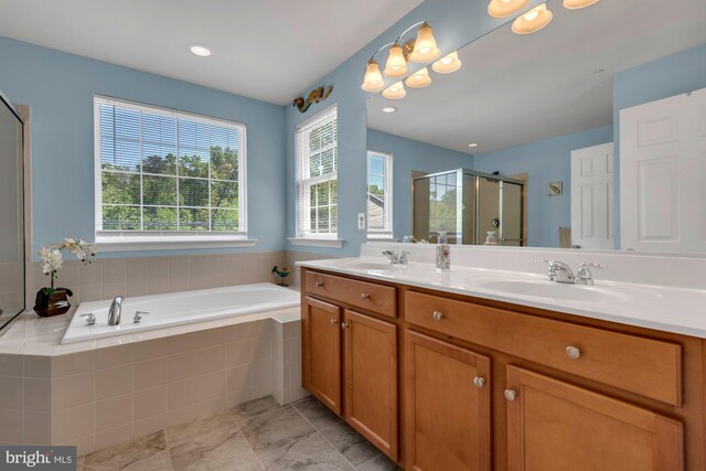 bathroom with a sink, double vanity, a stall shower, and a bath