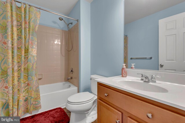 full bath featuring vanity, shower / bath combination with curtain, and toilet
