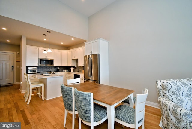 dining area featuring recessed lighting, baseboards, a toaster, and light wood-style floors