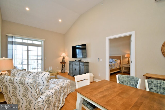 living room featuring baseboards, recessed lighting, high vaulted ceiling, and light wood-style flooring