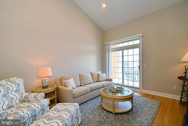 living room featuring recessed lighting, baseboards, wood finished floors, and high vaulted ceiling