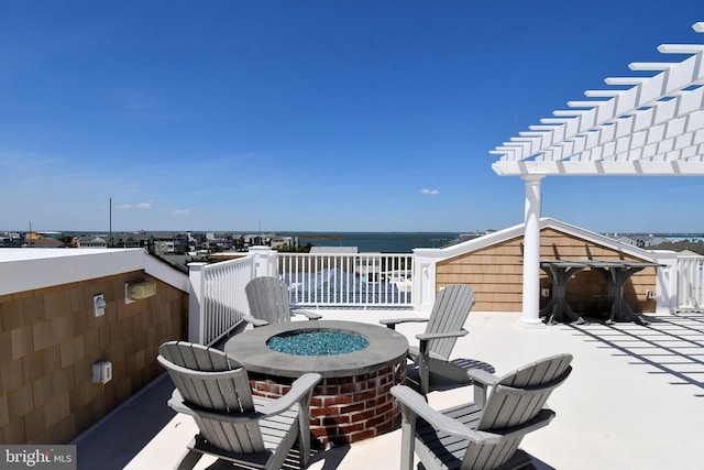 wooden deck featuring a water view, a fire pit, and a pergola