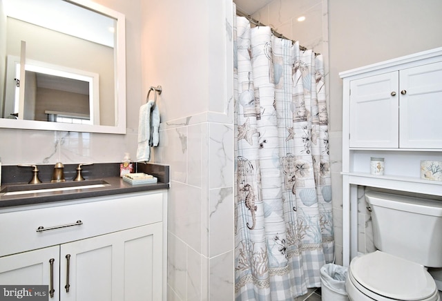 bathroom with toilet, tile walls, a shower with shower curtain, and vanity