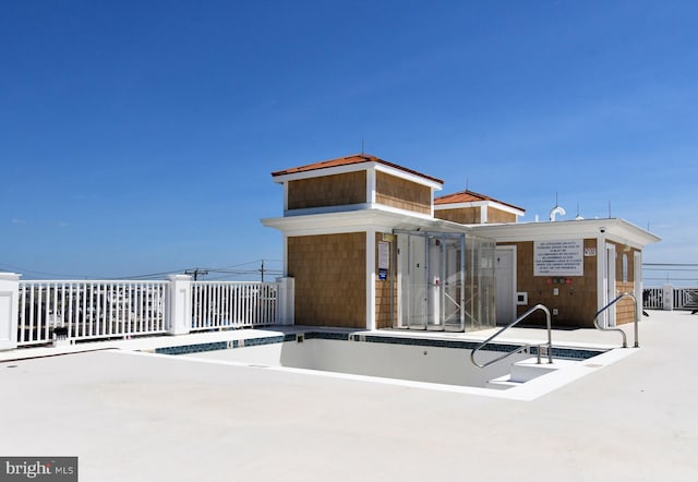 rear view of property featuring fence