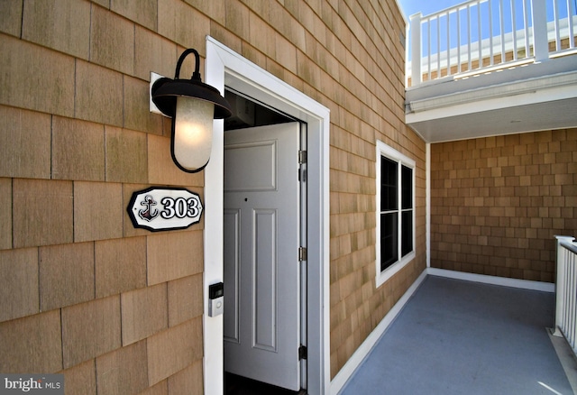 view of exterior entry with a balcony