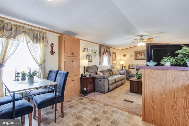 living room with a healthy amount of sunlight, visible vents, a ceiling fan, and lofted ceiling