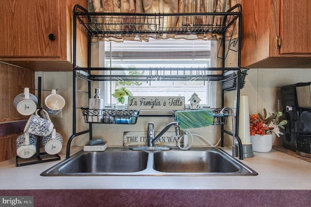 room details with brown cabinets, a sink, and light countertops