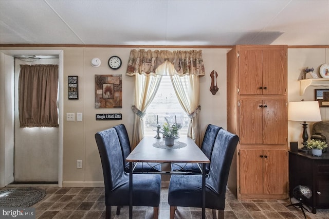 dining room featuring stone finish floor and baseboards