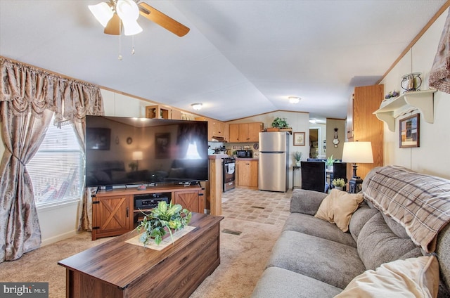 living area featuring a ceiling fan, baseboards, light colored carpet, and lofted ceiling