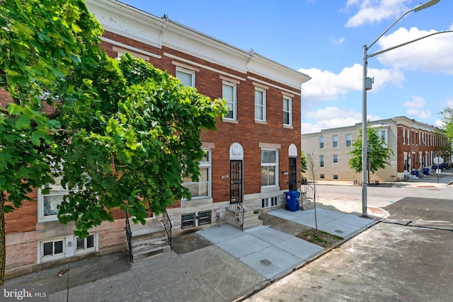 townhome / multi-family property featuring brick siding and entry steps
