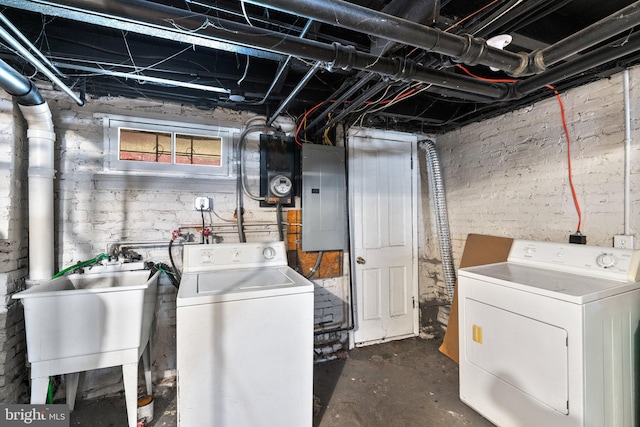 clothes washing area featuring laundry area, washing machine and dryer, a sink, and electric panel