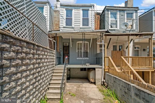 exterior space with a chimney, covered porch, and stairway