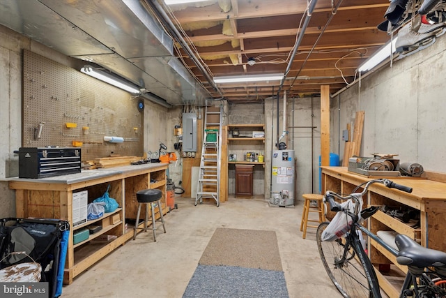 below grade area featuring a workshop area, water heater, and electric panel