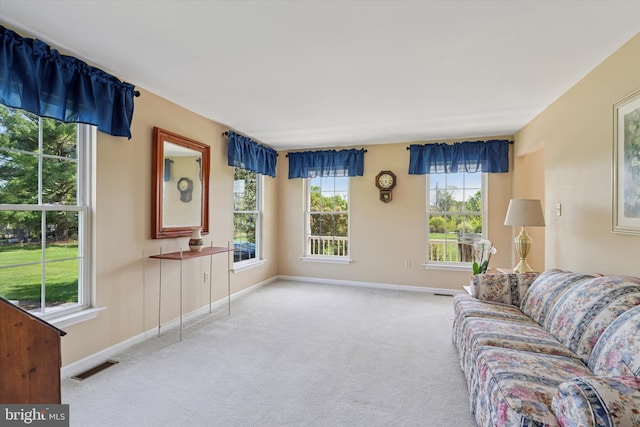 carpeted living room with baseboards and visible vents