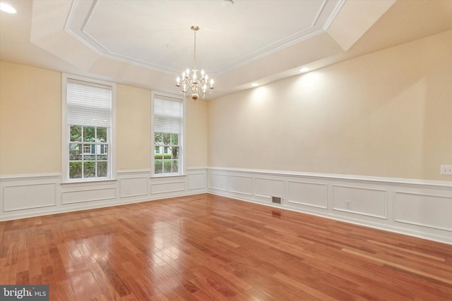 137 Mahogany Way, Upper Gwynedd, PA 19446 - empty room featuring a raised ceiling, a chandelier, wood finished floors, crown molding, and wainscoting