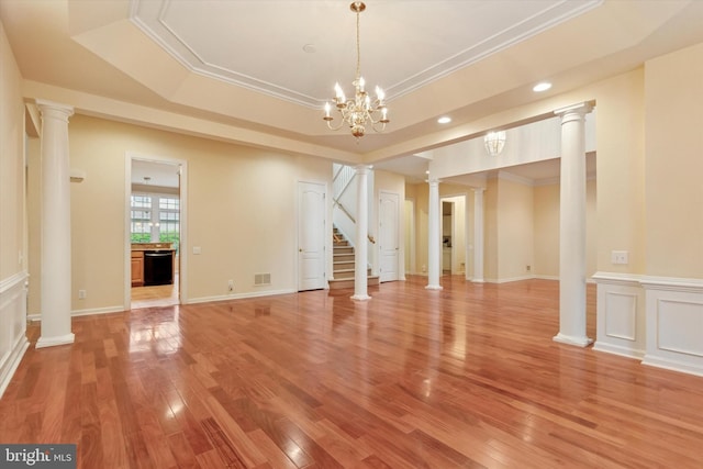 137 Mahogany Way, Upper Gwynedd, PA 19446 - unfurnished living room featuring ornate columns, a raised ceiling, light wood-type flooring, recessed lighting, and a chandelier