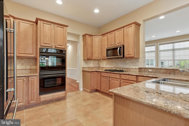 137 Mahogany Way, Upper Gwynedd, PA 19446 - kitchen with stainless steel microwave, light stone counters, tasteful backsplash, a sink, and recessed lighting