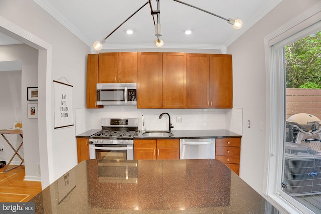 2019 Pemberton St, Philadelphia, PA 19146 - kitchen featuring appliances with stainless steel finishes, a sink, ornamental molding, dark stone countertops, and decorative backsplash