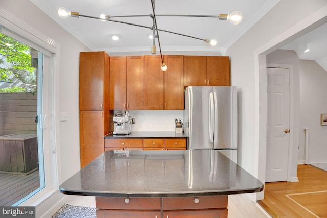 2019 Pemberton St, Philadelphia, PA 19146 - kitchen featuring freestanding refrigerator, tasteful backsplash, dark stone counters, brown cabinetry, and ornamental molding