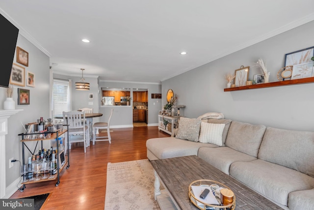 living room with recessed lighting, baseboards, ornamental molding, and wood finished floors