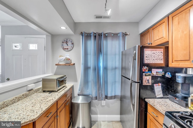 kitchen featuring gas range, light stone countertops, a toaster, baseboards, and recessed lighting