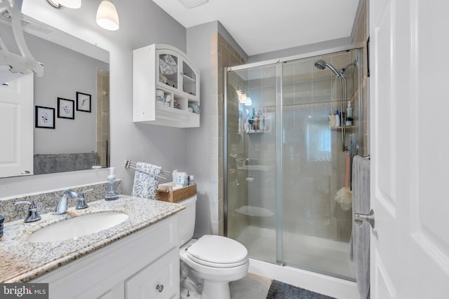 full bathroom with toilet, a shower stall, and vanity