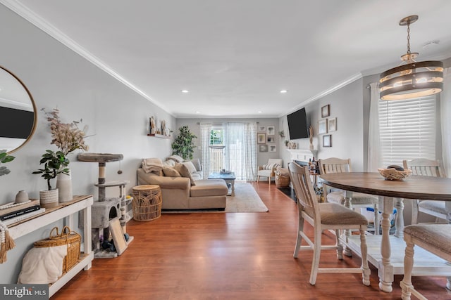 dining room featuring ornamental molding, recessed lighting, and wood finished floors
