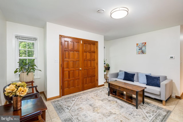 living room with baseboards and light tile patterned flooring