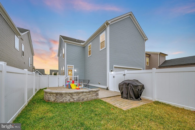 rear view of property featuring a lawn, a patio, and a fenced backyard