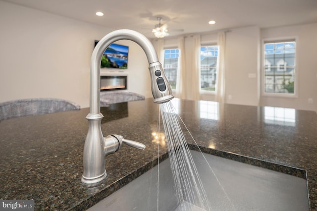 interior details with recessed lighting, a sink, dark stone countertops, and white cabinets