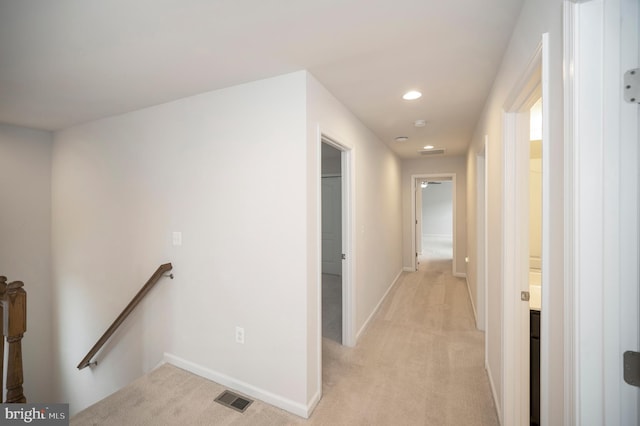 hall with visible vents, light colored carpet, baseboards, an upstairs landing, and recessed lighting