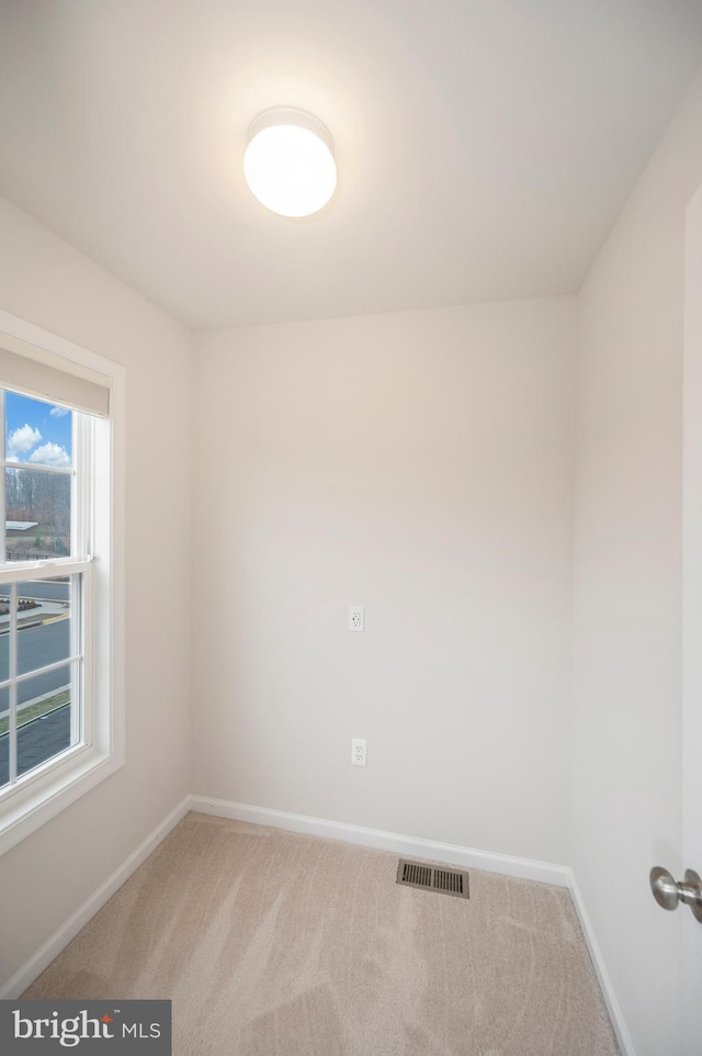 unfurnished room featuring visible vents, carpet, and baseboards