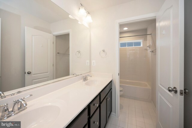 full bath featuring double vanity, toilet, a sink, and tile patterned flooring