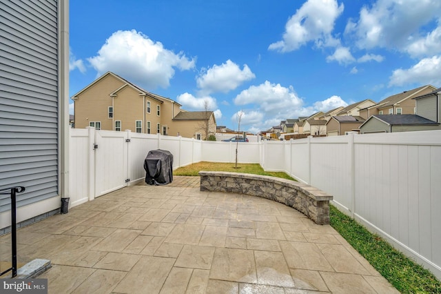 view of patio featuring a gate, a residential view, and a fenced backyard